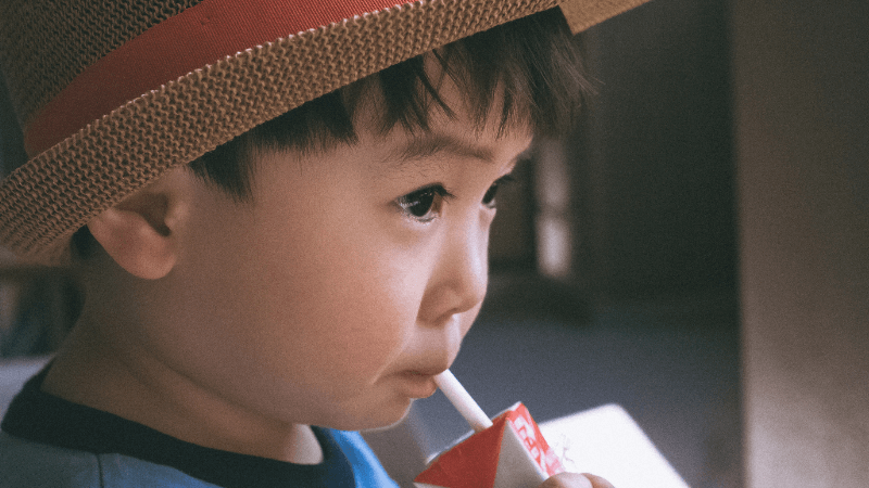 無添加ストレートジュースを飲んでいる子供